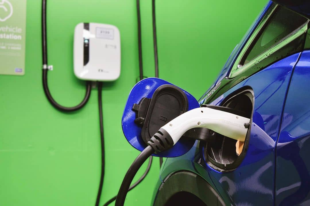 A blue electric vehicle charging at a Level 2 station